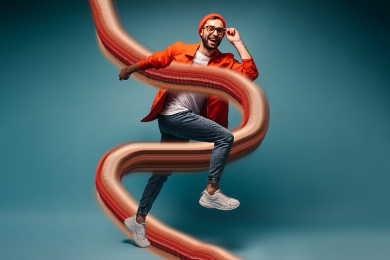 Cool guy in good mood posing on blue background and jumping
